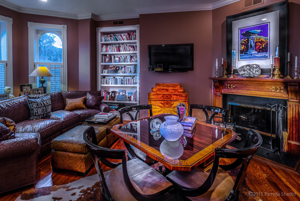 Cette photo montre une salle de séjour éclectique de taille moyenne et ouverte avec une cheminée standard, un manteau de cheminée en bois, un mur violet, un sol en bois brun et un téléviseur fixé au mur.