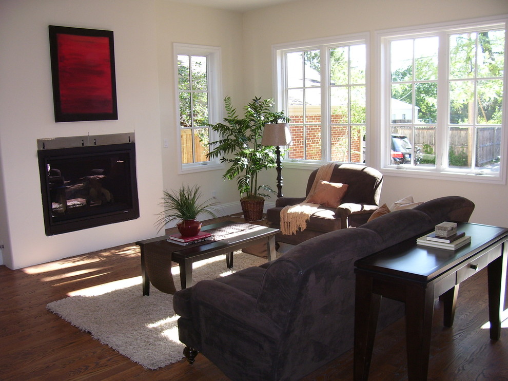 Modelo de sala de estar contemporánea sin televisor con paredes beige, suelo de madera en tonos medios y todas las chimeneas