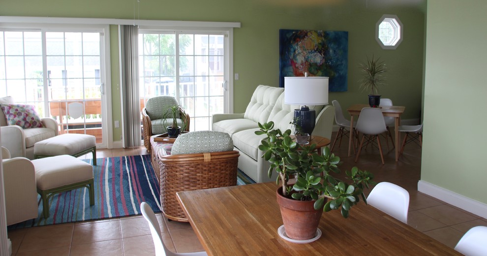 Imagen de sala de estar abierta costera pequeña sin chimenea con paredes verdes, suelo de baldosas de cerámica y televisor independiente