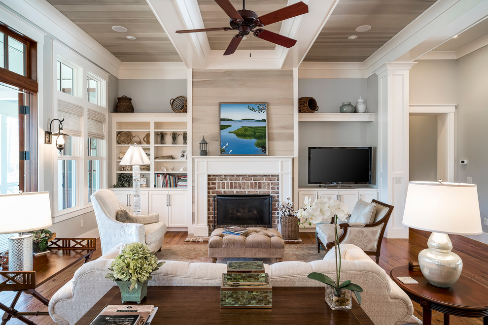 Design ideas for a large traditional open plan living room in Charleston with grey walls, medium hardwood flooring, a standard fireplace, a brick fireplace surround, a built-in media unit and feature lighting.