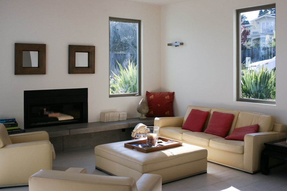 Imagen de sala de estar con biblioteca abierta actual de tamaño medio sin televisor con paredes blancas, suelo de baldosas de porcelana y chimenea lineal