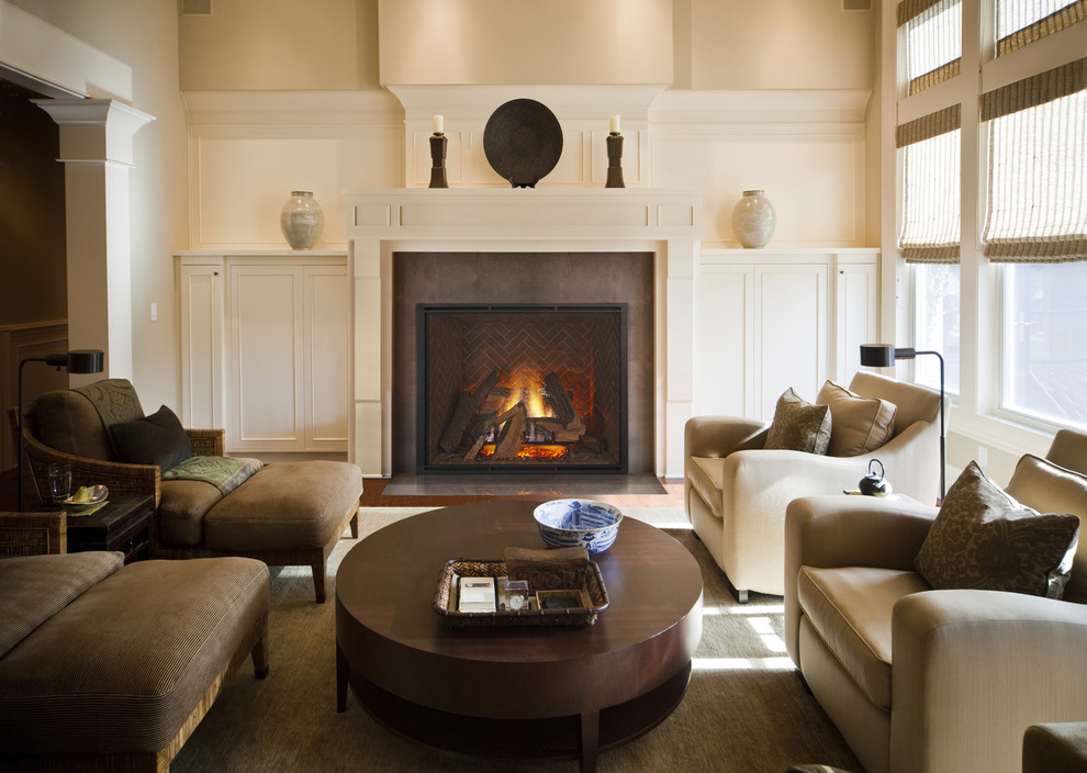 Exemple d'une salle de séjour craftsman de taille moyenne et fermée avec un mur beige, un sol en bois brun, une cheminée standard et un manteau de cheminée en bois.