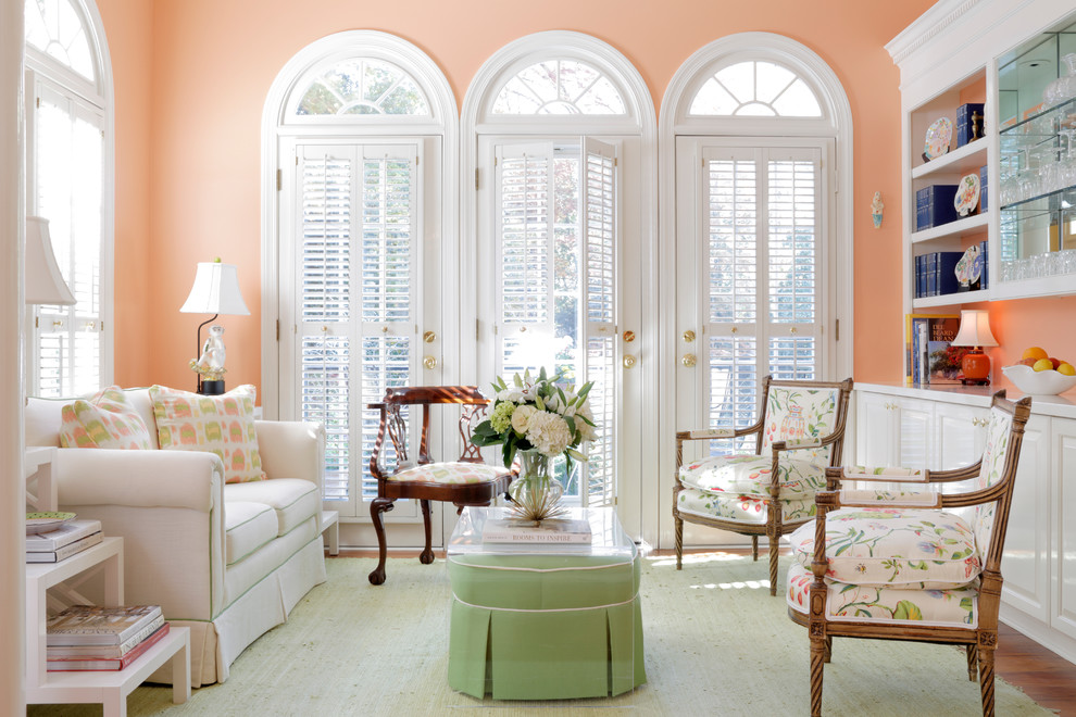 Family room - traditional enclosed medium tone wood floor family room idea in Atlanta with pink walls and no tv