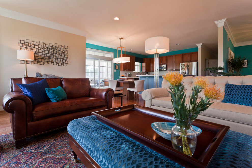 Imagen de sala de estar abierta clásica renovada grande con paredes azules, suelo de madera en tonos medios, todas las chimeneas, marco de chimenea de yeso, televisor colgado en la pared y suelo marrón