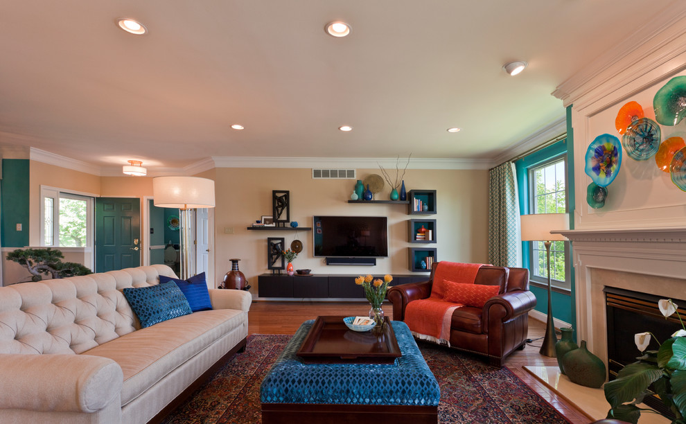 Foto de sala de estar abierta tradicional renovada grande con paredes azules, suelo de madera en tonos medios, todas las chimeneas, marco de chimenea de yeso, televisor colgado en la pared y suelo marrón