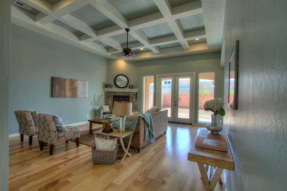 Mittelgroßes, Abgetrenntes Klassisches Wohnzimmer mit blauer Wandfarbe, hellem Holzboden, Eckkamin und Kaminumrandung aus Stein in Albuquerque