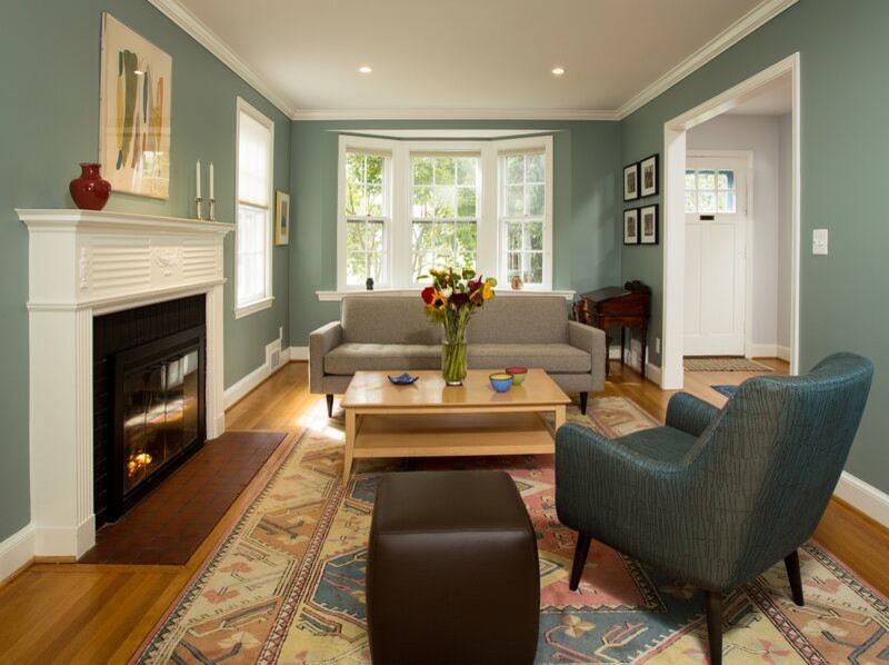 Example of a mid-sized transitional enclosed medium tone wood floor family room design in DC Metro with blue walls, a standard fireplace and a wood fireplace surround