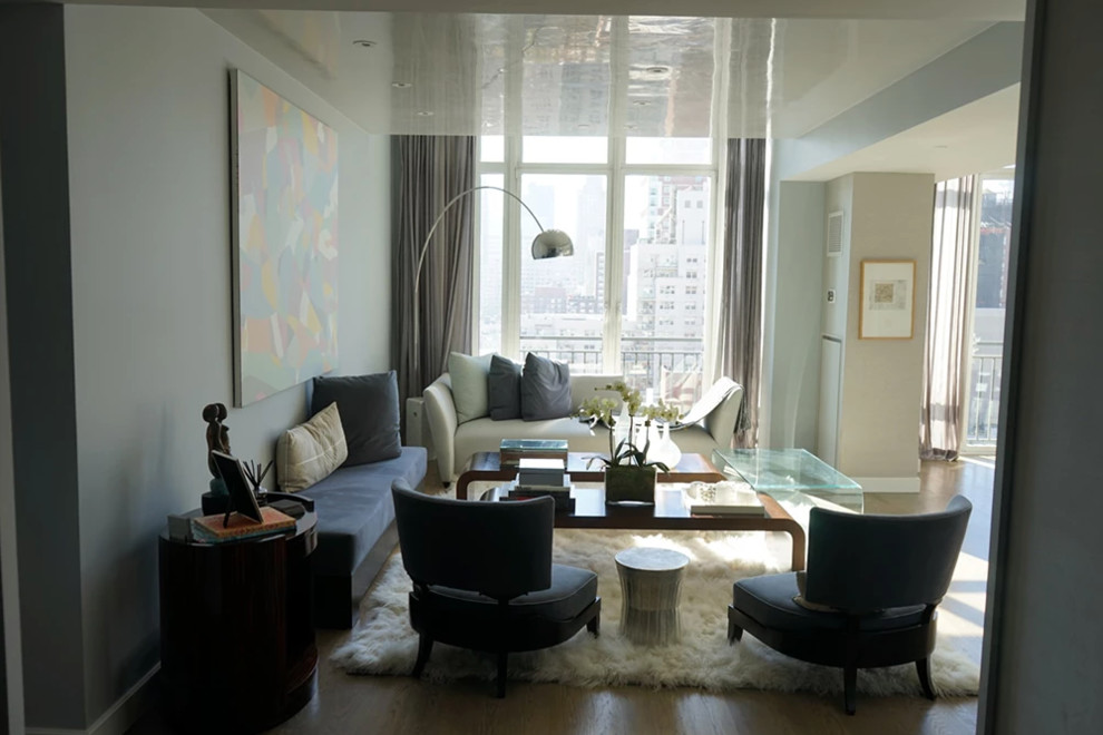 Idée de décoration pour une salle de séjour design de taille moyenne et ouverte avec un mur blanc, moquette, un téléviseur encastré et un sol beige.