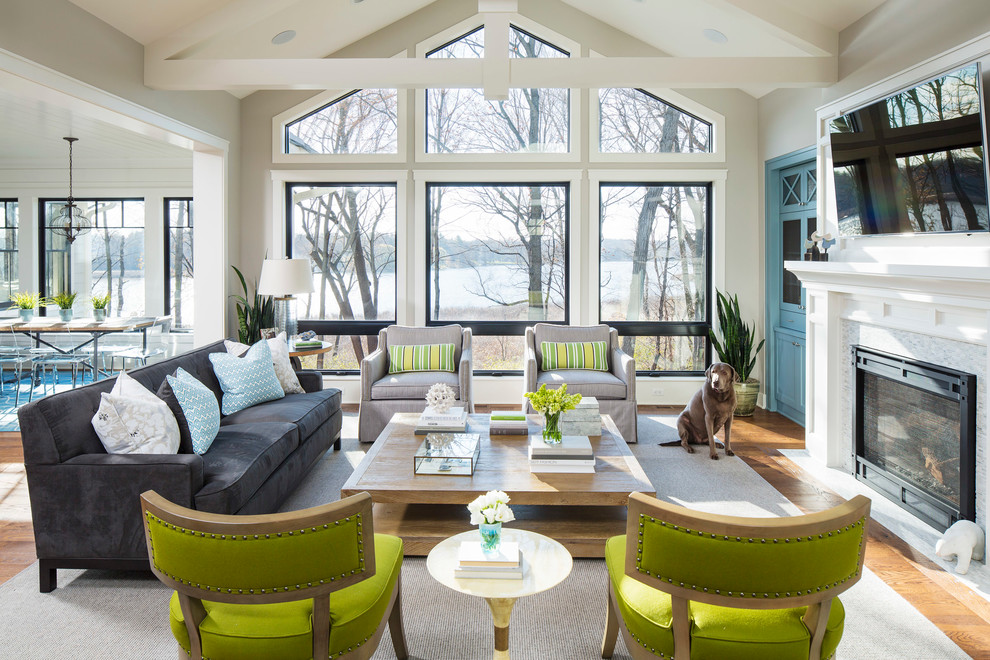 Inspiration for a coastal open concept medium tone wood floor family room remodel in Minneapolis with gray walls, a standard fireplace, a wall-mounted tv and a tile fireplace