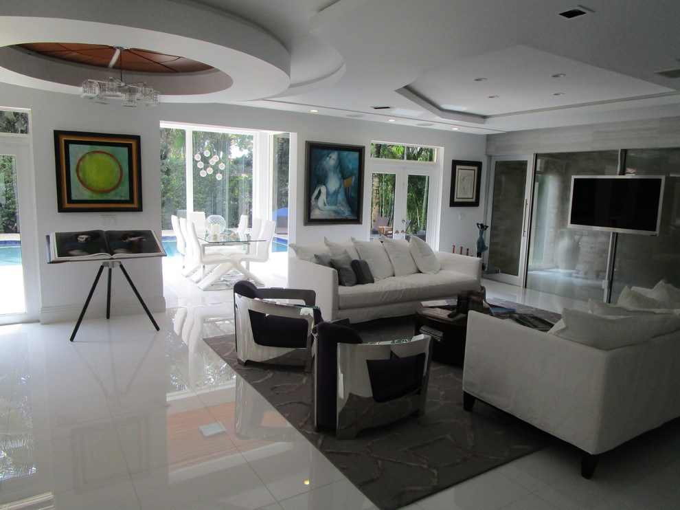 Medium sized eclectic open plan games room in Miami with white walls, marble flooring, a wall mounted tv and white floors.
