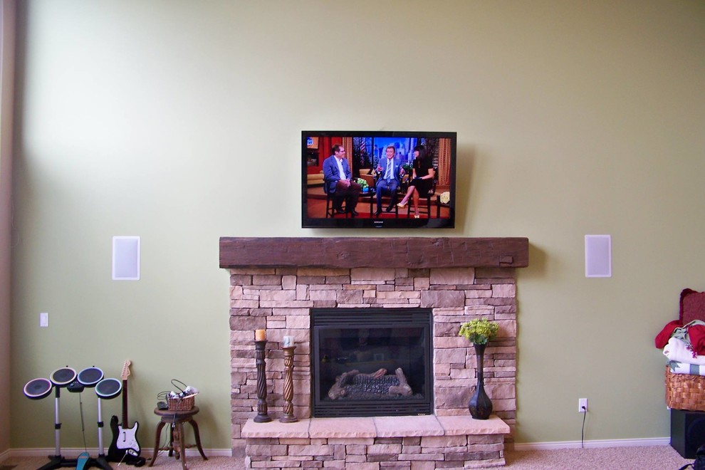 This is an example of a medium sized traditional enclosed games room in Detroit with green walls, carpet, a standard fireplace, a stone fireplace surround, a wall mounted tv, a game room and beige floors.