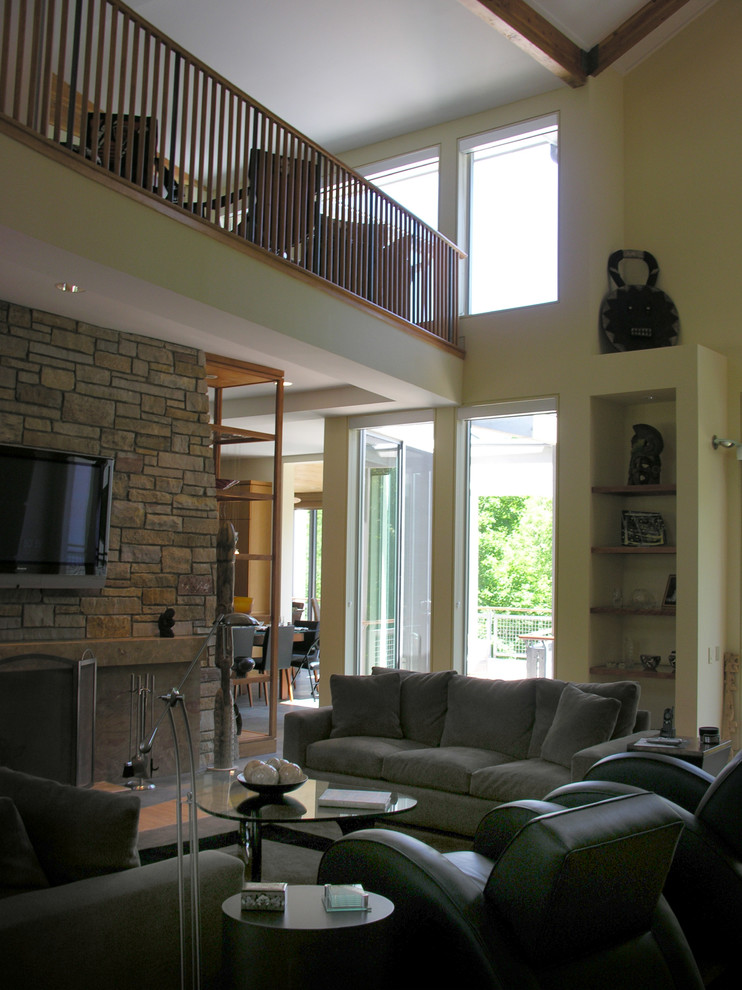 Exemple d'une grande salle de séjour tendance ouverte avec un mur beige, parquet clair, une cheminée standard, un manteau de cheminée en pierre et un téléviseur fixé au mur.