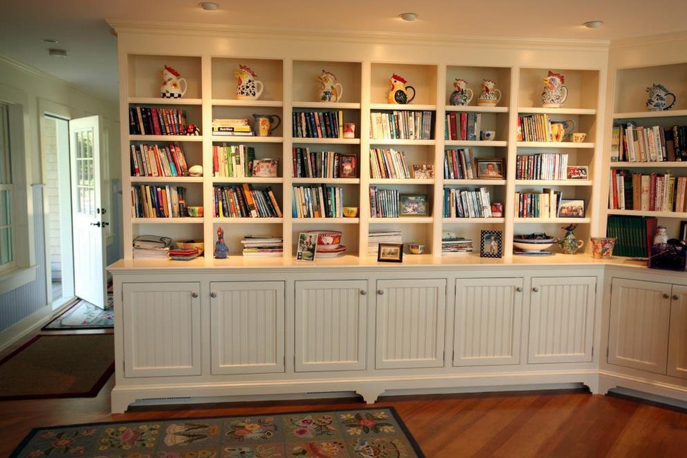 Diseño de sala de estar con biblioteca de estilo de casa de campo grande sin chimenea con suelo de madera en tonos medios y suelo marrón