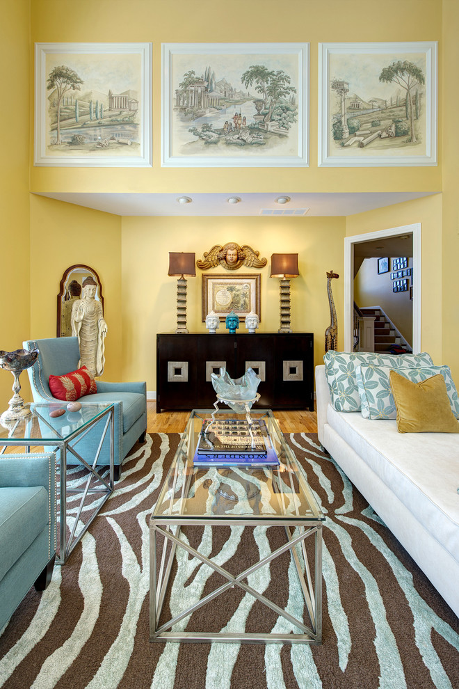 На фото: открытая гостиная комната среднего размера в восточном стиле с желтыми стенами, светлым паркетным полом, стандартным камином и коричневым полом с