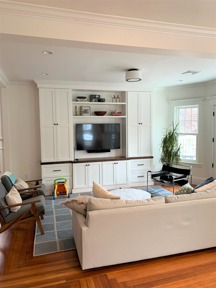 Idee per un soggiorno chic aperto con pareti bianche, pavimento in legno massello medio e parete attrezzata
