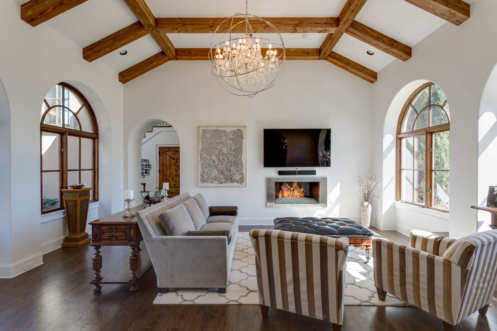 Diseño de sala de estar tradicional renovada con paredes blancas, suelo de madera oscura, todas las chimeneas, marco de chimenea de metal y televisor colgado en la pared