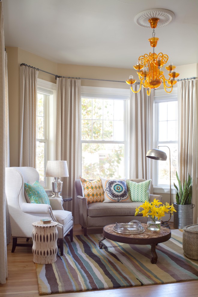 Example of a trendy medium tone wood floor family room design in Denver with beige walls