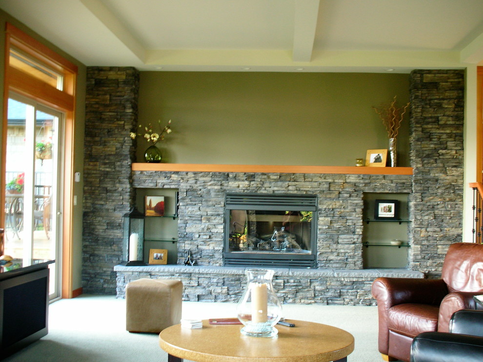 Пример оригинального дизайна: большая открытая гостиная комната в классическом стиле с домашним баром, зелеными стенами, ковровым покрытием, стандартным камином, фасадом камина из камня и скрытым телевизором