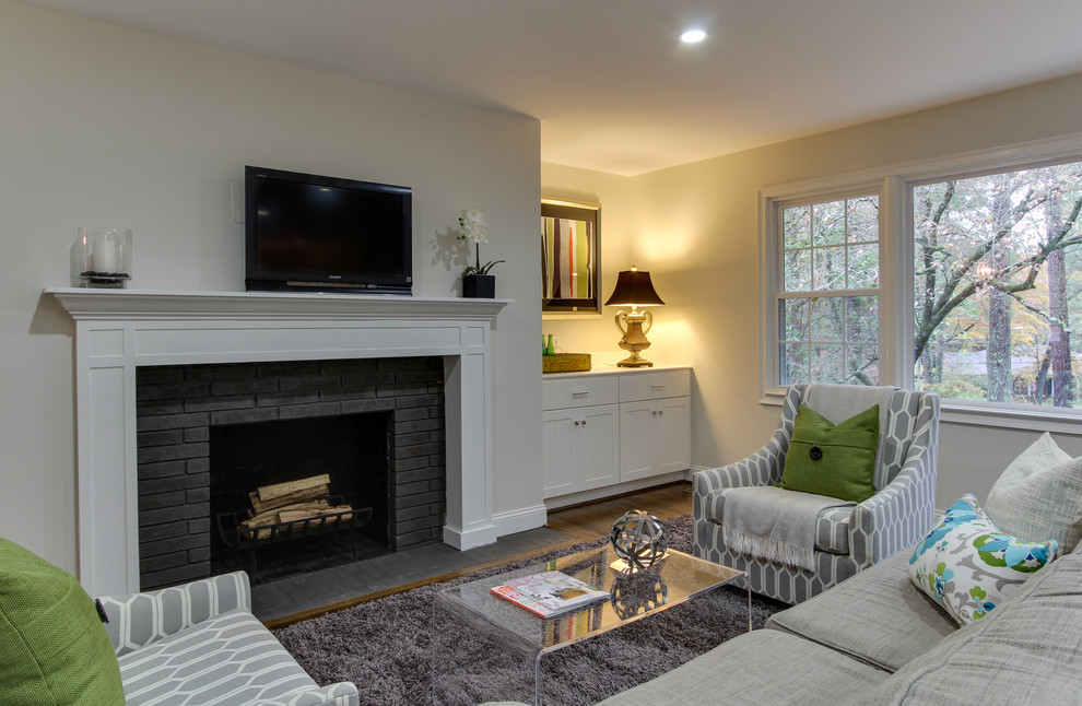 Family room - mid-sized transitional open concept dark wood floor family room idea in Raleigh with white walls, a standard fireplace, a brick fireplace and a wall-mounted tv