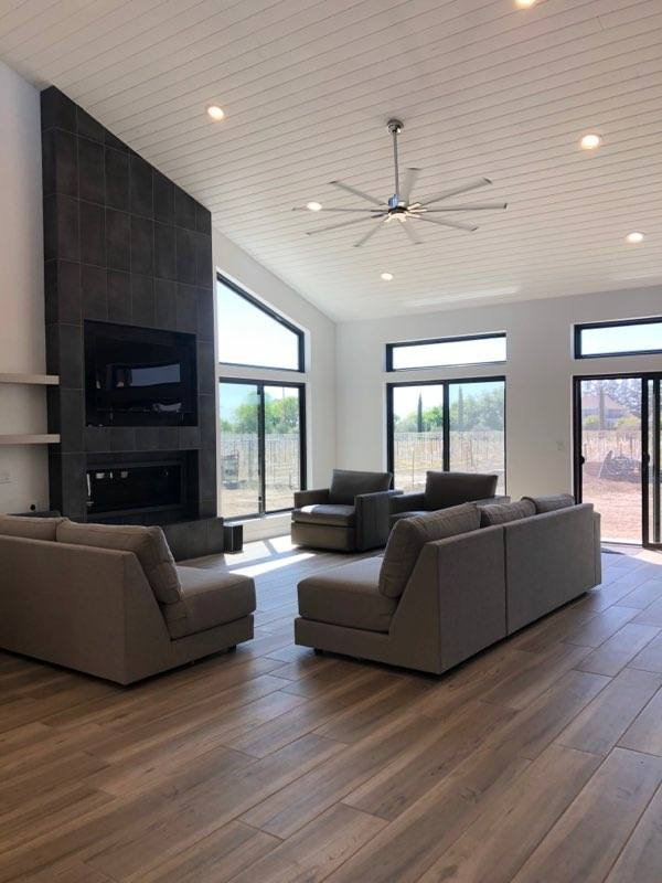 Inspiration for a large contemporary open concept ceramic tile, gray floor and vaulted ceiling family room remodel in Sacramento with white walls, a ribbon fireplace, a tile fireplace and a wall-mounted tv