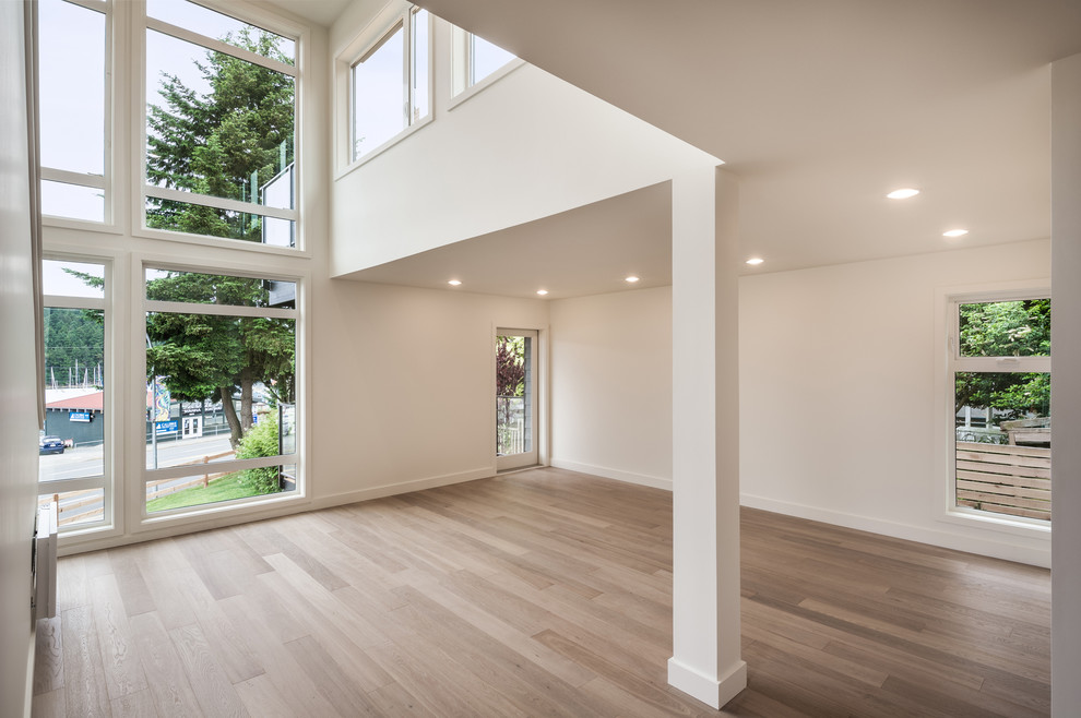 Diseño de sala de estar tipo loft minimalista extra grande con paredes blancas y suelo de madera clara