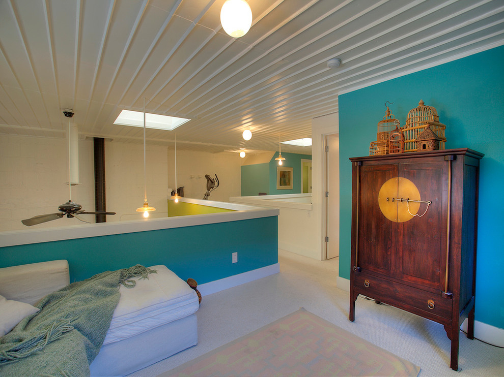 Imagen de sala de estar tipo loft industrial pequeña con paredes azules, moqueta y televisor retractable
