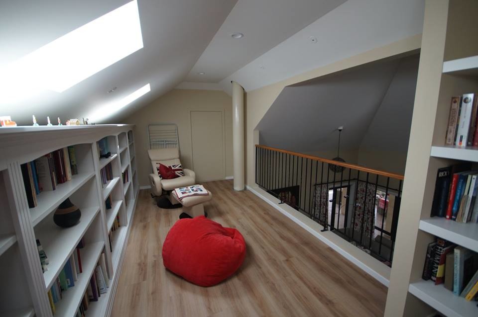 Exemple d'une salle de séjour mansardée ou avec mezzanine tendance avec une bibliothèque ou un coin lecture et un mur blanc.