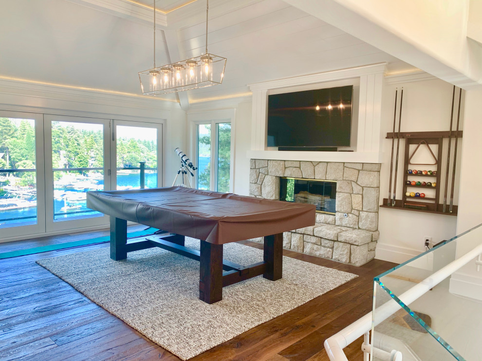 Photo of a large contemporary mezzanine games room in San Diego with a game room, white walls, dark hardwood flooring, a standard fireplace, a stone fireplace surround, a wall mounted tv, brown floors and a timber clad ceiling.