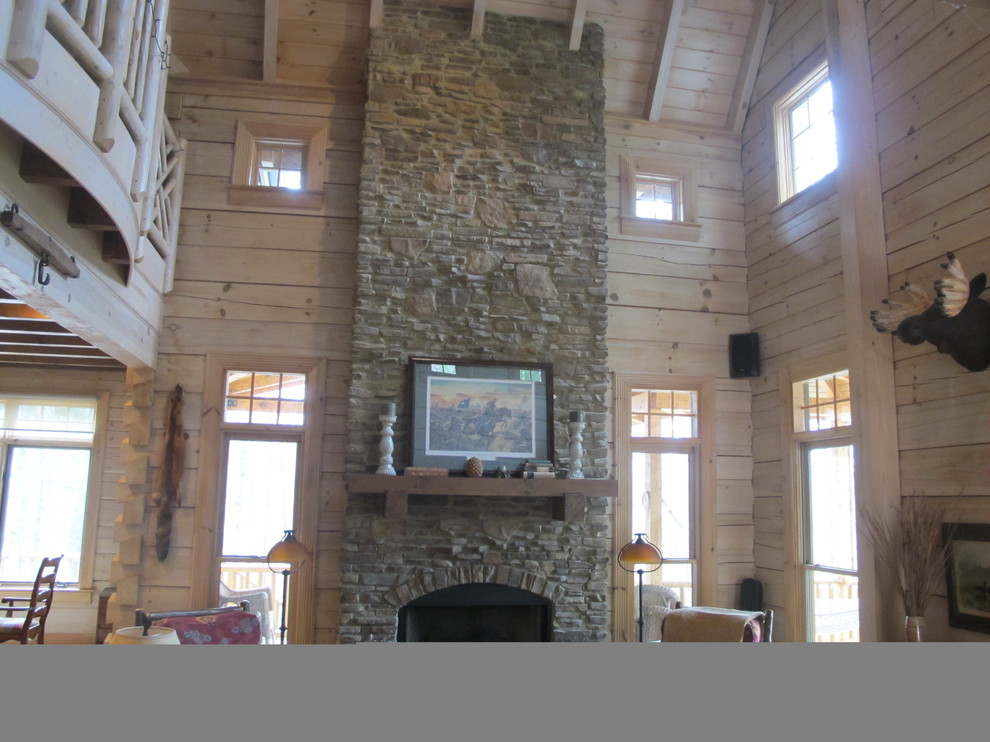 Diseño de sala de estar abierta rústica grande sin televisor con paredes marrones, suelo de madera clara, todas las chimeneas y marco de chimenea de piedra