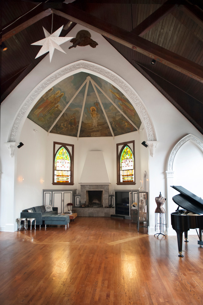 Offenes Klassisches Musikzimmer mit weißer Wandfarbe, braunem Holzboden, Kamin, gefliester Kaminumrandung und braunem Boden in Los Angeles