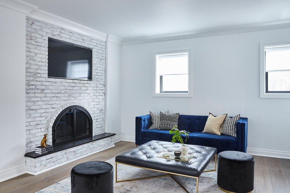 Diseño de sala de estar abierta contemporánea de tamaño medio con paredes blancas, todas las chimeneas, marco de chimenea de ladrillo, pared multimedia y suelo gris