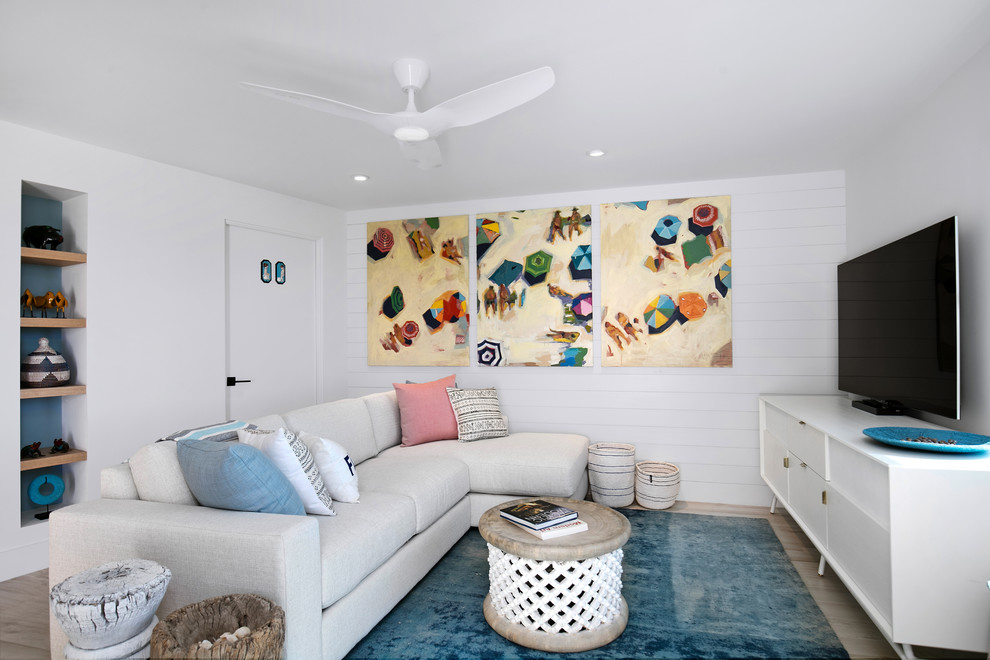 Diseño de sala de estar abierta marinera pequeña con paredes blancas, suelo beige y televisor independiente