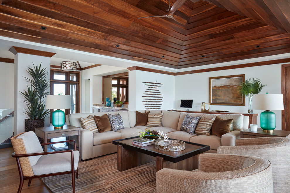 Foto di un grande soggiorno tropicale aperto con angolo bar, pavimento in legno massello medio, pavimento marrone e pareti bianche