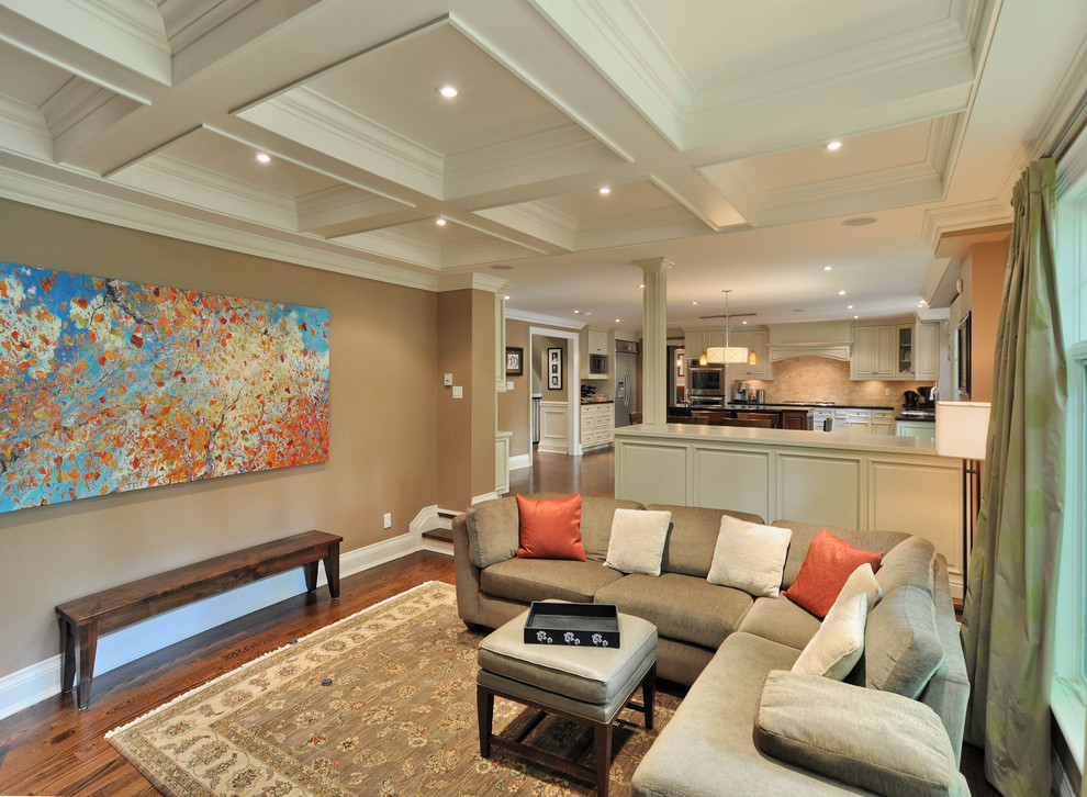 Imagen de sala de estar abierta clásica grande sin chimenea y televisor con paredes beige y suelo de madera en tonos medios