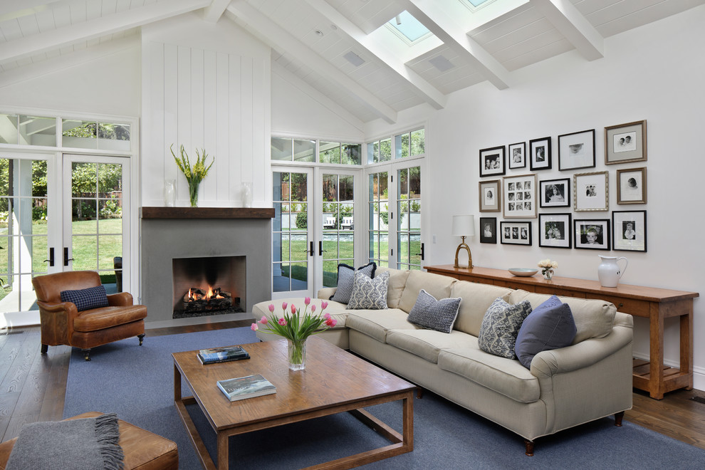 Imagen de sala de estar clásica con paredes blancas, suelo de madera oscura, todas las chimeneas y alfombra