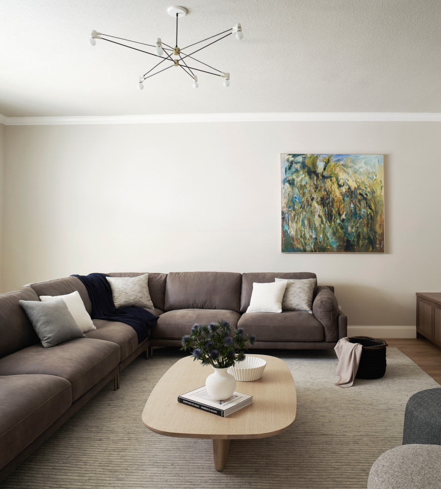 Immagine di un grande soggiorno design chiuso con pareti beige, parquet chiaro, nessun camino e TV a parete
