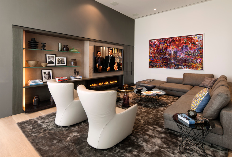 На фото: гостиная комната в современном стиле с светлым паркетным полом, телевизором на стене, горизонтальным камином, разноцветными стенами и ковром на полу