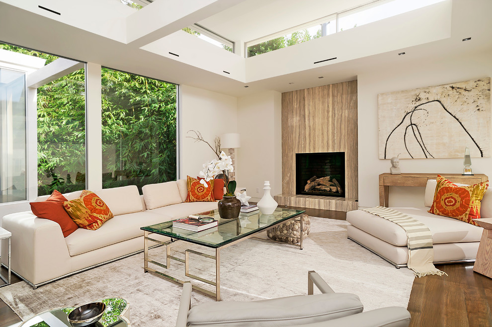 Offenes Modernes Wohnzimmer mit weißer Wandfarbe, braunem Holzboden, Kamin, Kaminumrandung aus Holz und braunem Boden in Dallas