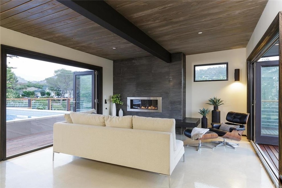 Ejemplo de sala de estar cerrada minimalista de tamaño medio sin televisor con paredes blancas, suelo de linóleo, chimenea lineal y marco de chimenea de metal