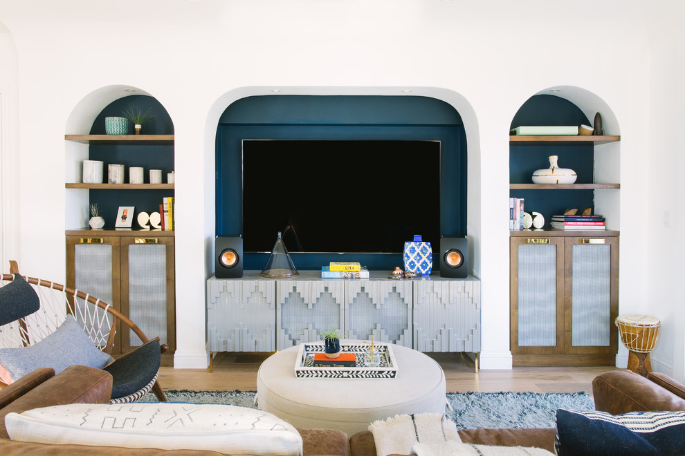 Foto de sala de estar abierta mediterránea con paredes multicolor, suelo de madera clara y pared multimedia
