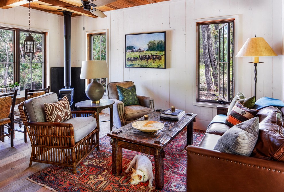 Esempio di un soggiorno stile rurale aperto con pavimento in legno massello medio e stufa a legna