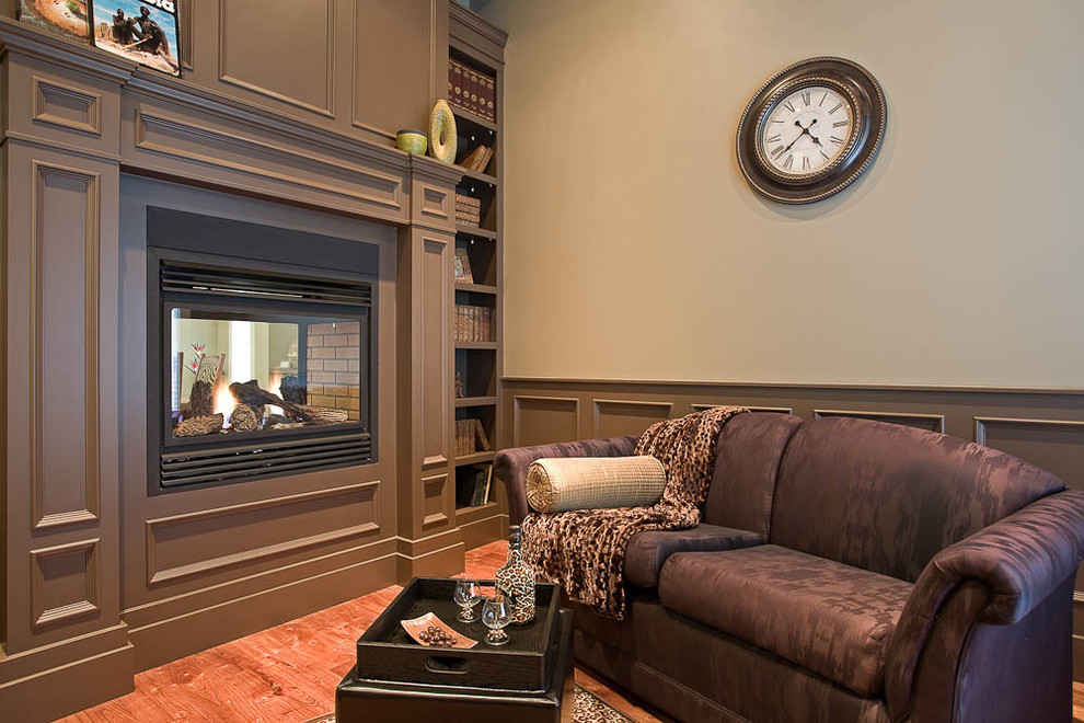 На фото: гостиная комната в классическом стиле с двусторонним камином с