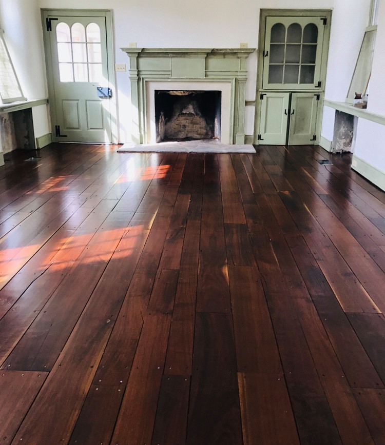 Small transitional enclosed dark wood floor and brown floor family room photo in Philadelphia with white walls, a standard fireplace and a wood fireplace surround