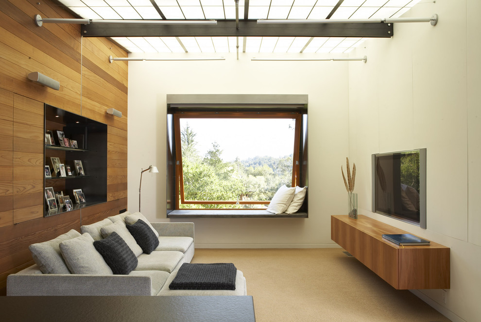 Inspiration for a modern family room remodel in San Francisco with beige walls and a wall-mounted tv