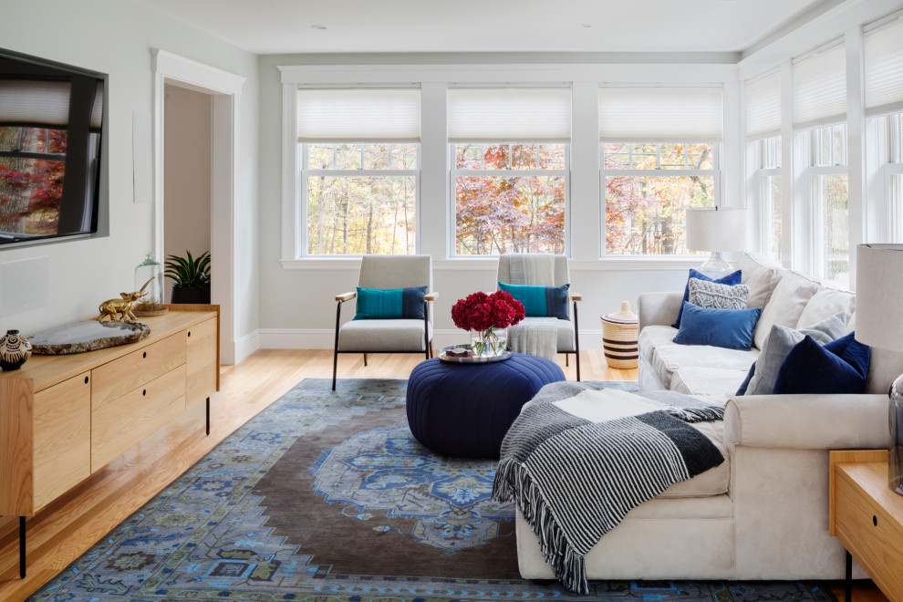 Modelo de sala de estar tradicional renovada grande con paredes blancas, suelo de madera en tonos medios, televisor colgado en la pared y suelo beige