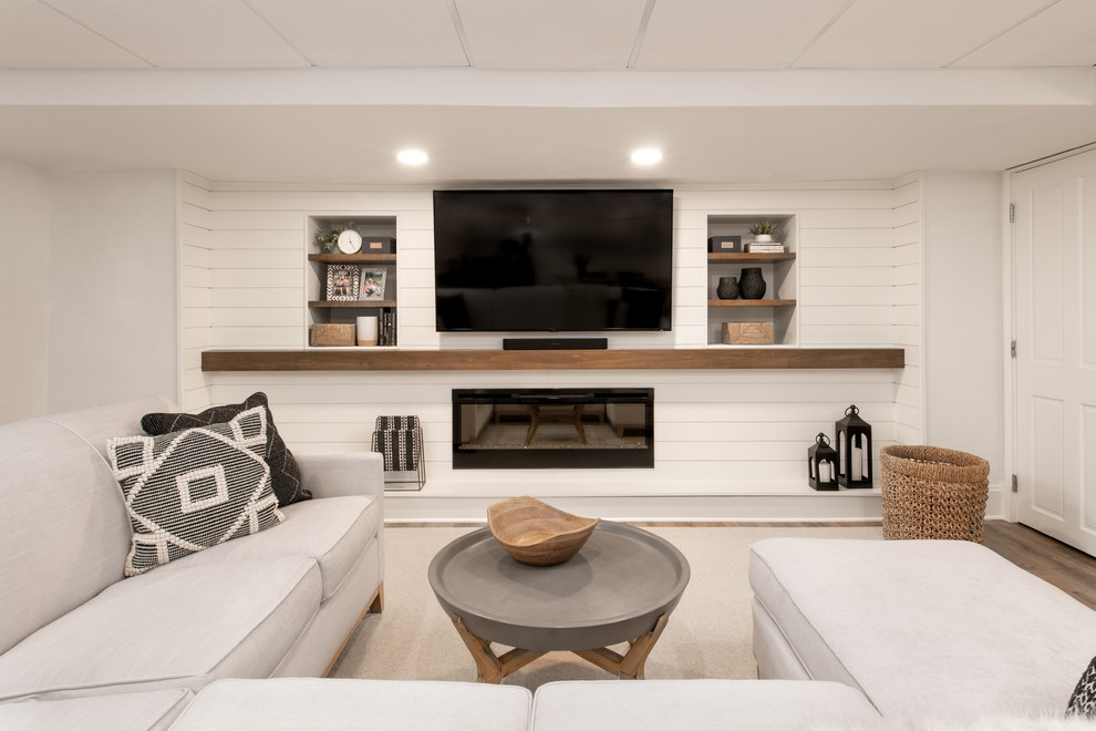 Идея дизайна: изолированная гостиная комната среднего размера в классическом стиле с белыми стенами, полом из ламината, подвесным камином, фасадом камина из дерева, телевизором на стене и коричневым полом