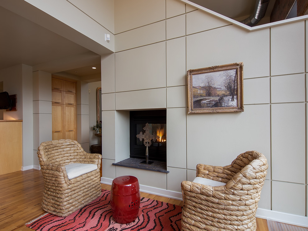 This is an example of a world-inspired open plan games room in Denver with medium hardwood flooring and a standard fireplace.