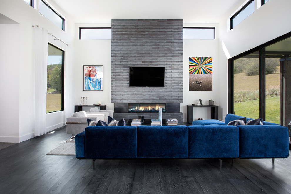 Photo of a contemporary open plan games room in Salt Lake City with white walls, a wall mounted tv and black floors.