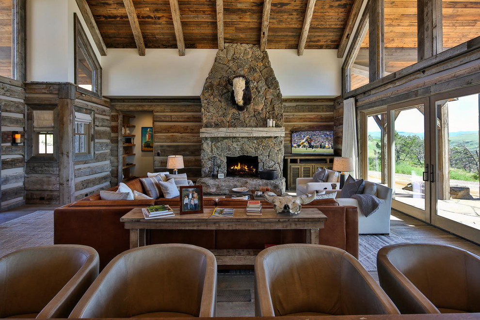 Foto de sala de estar abierta, rural, con todas las chimeneas y televisor independiente