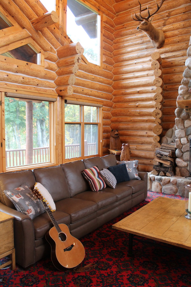 Cette image montre une grande salle de séjour chalet avec moquette, une cheminée standard, un manteau de cheminée en pierre et un sol rouge.